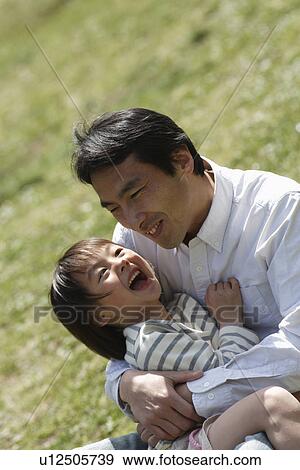 Stock Photo - Father and daughter enjoying in garden. Fotosearch