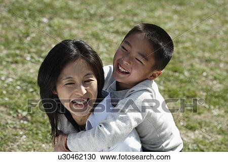 Mother carrying son on her back View Large Photo Image Stock Image - Mother carrying son on her back. Fotosearch