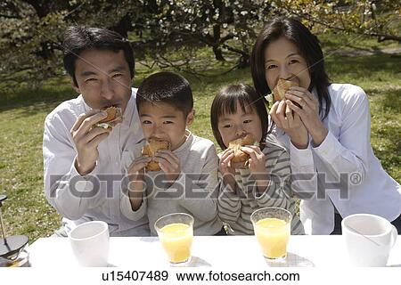 Portrait of a family eating breakfast in garden View Large Photo Image Stock Photo - Portrait of a family eating breakfast in garden. Fotosearch