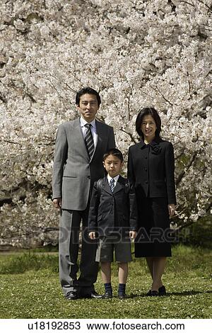 Portrait of a family standing under tree View Large Photo Image Stock Image - Portrait of a family standing under tree. Fotosearch