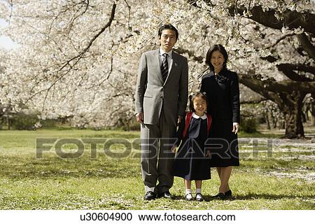 Portrait of a family standing under tree View Large Photo Image Stock Image - Portrait of a family standing under tree. Fotosearch