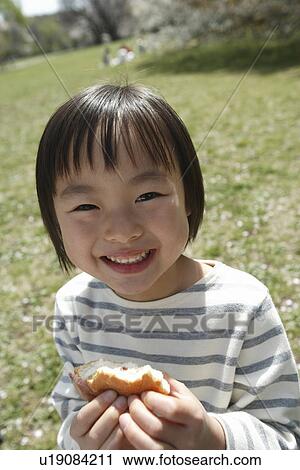 Stock Image - Portrait of a girl holding sandwich. Fotosearch