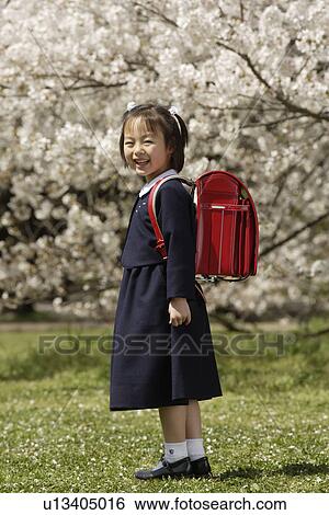 Stock Photograph - Portrait of a girl in school uniform smiling. Fotosearch