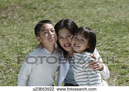 Portrait of a mother and children sitting in garden View Large Photo Image Stock Image - Portrait of a mother and children sitting in garden. Fotosearch