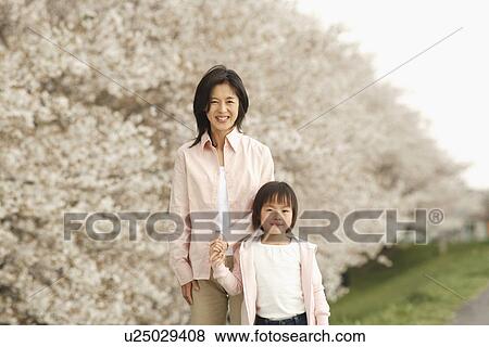 Stock Photo - Portrait of a mother and daughter standing together. Fotosearch