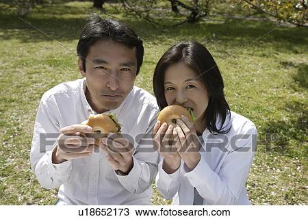 Portrait of couple eating sandwich in garden View Large Photo Image Stock Image - Portrait of couple eating sandwich in garden. Fotosearch