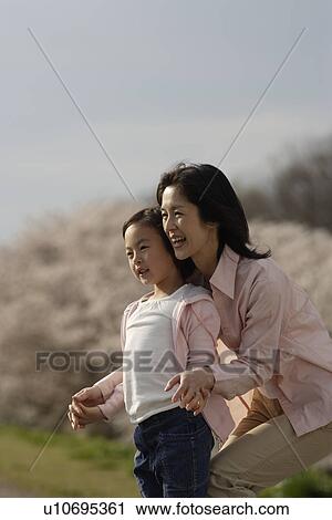 View of a daughter standing with mother View Large Photo Image Stock Image - View of a daughter standing with mother. Fotosearch