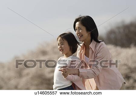Stock Photo - View of a daughter standing with mother. Fotosearch
