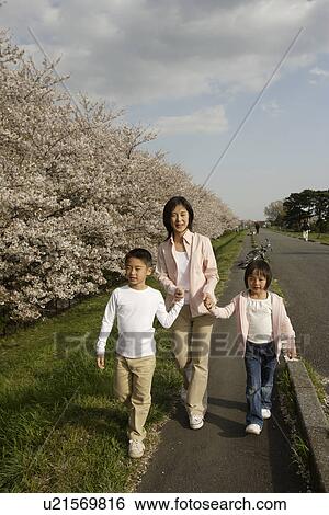 View of a mother and children walking on pathway View Large Photo Image Stock Photograph - View of a mother and children walking on pathway. Fotosearch