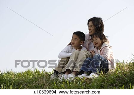 View of a mother sitting with son and daughter View Large Photo Image Picture - View of a mother sitting with son and daughter. Fotosearch