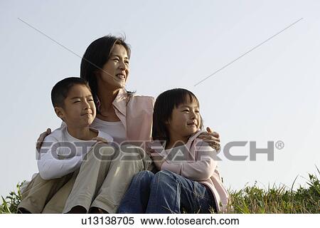 View of a mother sitting with son and daughter View Large Photo Image Stock Photography - View of a mother sitting with son and daughter. Fotosearch