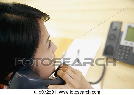 A high angle view of a woman conversing on the telephone View Large Photo Image Stock Image - A high angle view of a woman conversing on the telephone. Fotosearch