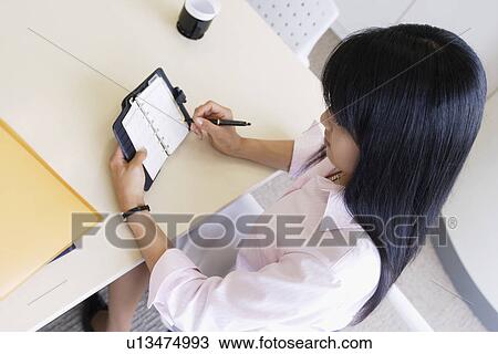 A woman having a look over her diary in her cabin View Large Photo Image Stock Image - A woman having a look over her diary in her cabin. Fotosearch