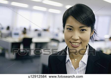 A woman smiles as she looks at the camera View Large Photo Image Picture - A woman smiles as she looks at the camera. Fotosearch
