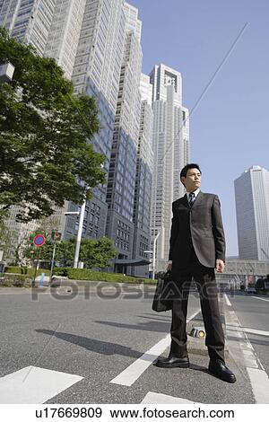 Businessman amid office buildings View Large Photo Image Stock Photo - Businessman amid office buildings. Fotosearch
