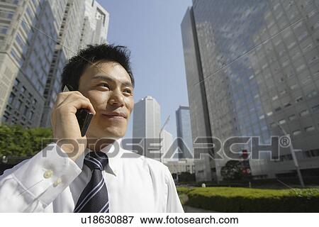 Stock Photo - Businessman conversing on a cellphone, portrait. Fotosearch