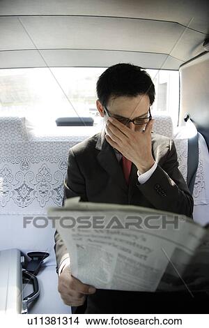 Businessman reading newspaper in car, portrait View Large Photo Image Picture - Businessman reading newspaper in car, portrait. Fotosearch