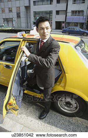 Businessman stepping out of a car View Large Photo Image Stock Image - Businessman stepping out of a car. Fotosearch