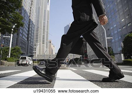 Businessman walking on a crosswalk View Large Photo Image Stock Photography - Businessman walking on a crosswalk. Fotosearch