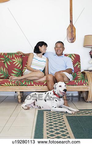A couple sitting on sofa View Large Photo Image Stock Image - A couple sitting on sofa. Fotosearch