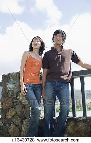 A young couple standing near railing View Large Photo Image Stock Photo - A young couple standing near railing. Fotosearch