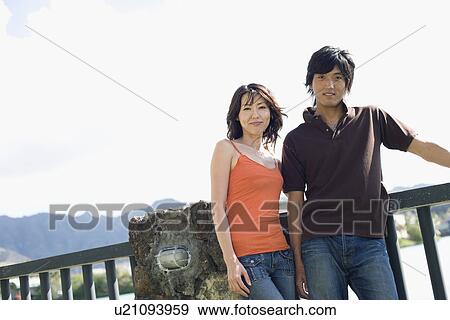 A young couple standing near railing View Large Photo Image Stock Photo - A young couple standing near railing. Fotosearch