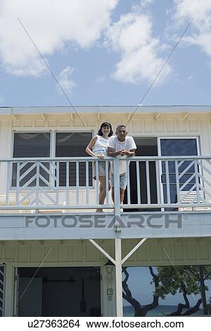 Picture - Low angle view of a couple on balcony. Fotosearch