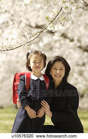 Stock Image - Portrait of mother and daughter smiling. Fotosearch