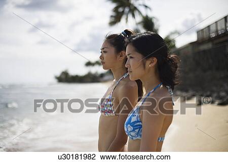 Stock Image - Profile of young women at beach. Fotosearch