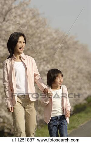 Stock Photo - View of a woman and daughter walking. Fotosearch