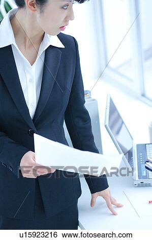 Stock Photograph - A young business woman working in office. Fotosearch