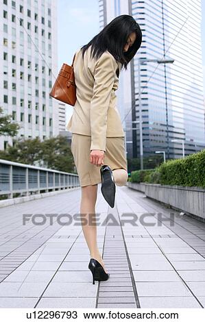 Stock Image - A young businesswoman checking heel. Fotosearch