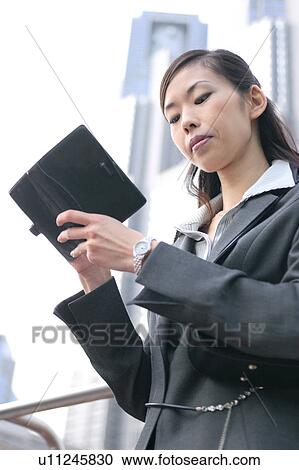 A young businesswoman checking schedule View Large Photo Image Stock Image - A young businesswoman checking schedule. Fotosearch