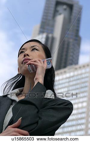 A young businesswoman talking over mobile phone View Large Photo Image Stock Image - A young businesswoman talking over mobile phone. Fotosearch