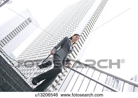 A young businesswoman walking down stairs View Large Photo Image Stock Photograph - A young businesswoman walking down stairs. Fotosearch
