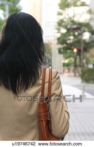 A young businesswoman walking, rear view View Large Photo Image Stock Image - A young businesswoman walking, rear view. Fotosearch