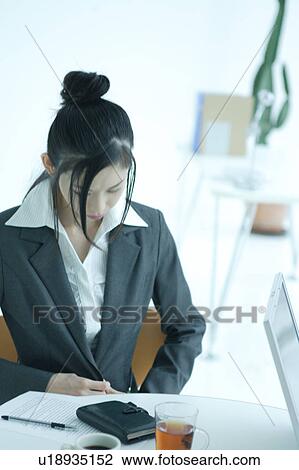 A young businesswoman working in office View Large Photo Image Stock Image - A young businesswoman working in office. Fotosearch