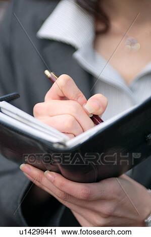 Stock Image - A young woman checking her schedule. Fotosearch