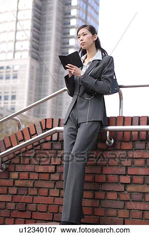 Stock Photo - A young woman checking schedule. Fotosearch