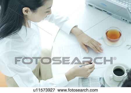 A young woman working in office View Large Photo Image Stock Photo - A young woman working in office. Fotosearch