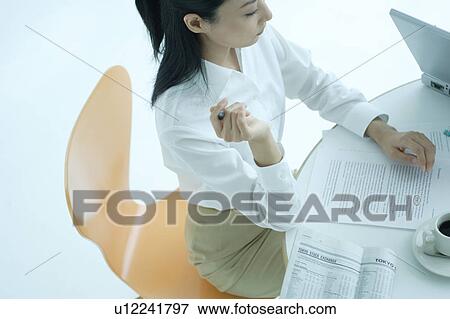 Stock Photo - A young woman working in office. Fotosearch
