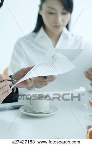 Stock Image - Small group of young women having meeting in office, close-up. Fotosearch