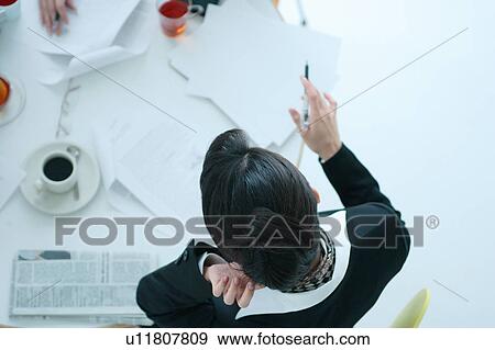 Stock Photo - Small group of young women having meeting in office, close-up. Fotosearch