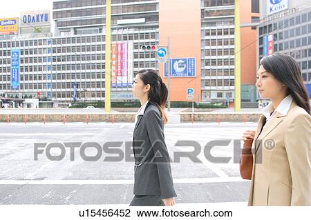 Stock Image - Two young businesswomen walking. Fotosearch