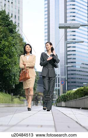 Two young businesswomen walking View Large Photo Image Stock Image - Two young businesswomen walking. Fotosearch