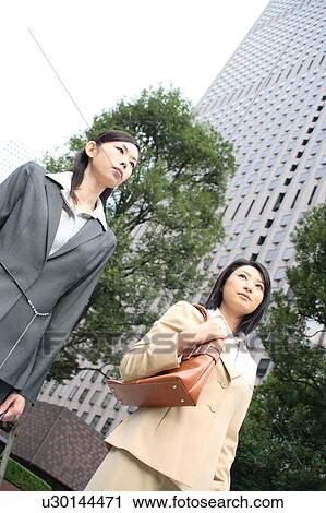 Two young businesswomen walking View Large Photo Image Stock Image - Two young businesswomen walking. Fotosearch