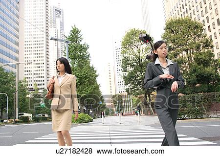 Stock Photo - Two young businesswomen walking. Fotosearch