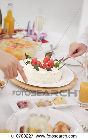 A young woman cutting strawberry cake View Large Photo Image Stock Photo - A young woman cutting strawberry cake. Fotosearch