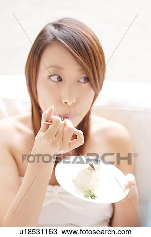 A young woman eating cake View Large Photo Image Stock Image - A young woman eating cake. Fotosearch