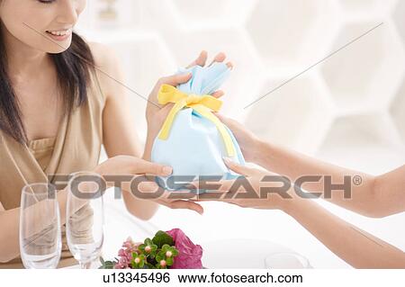 Stock Photograph - A young woman receiving a present. Fotosearch